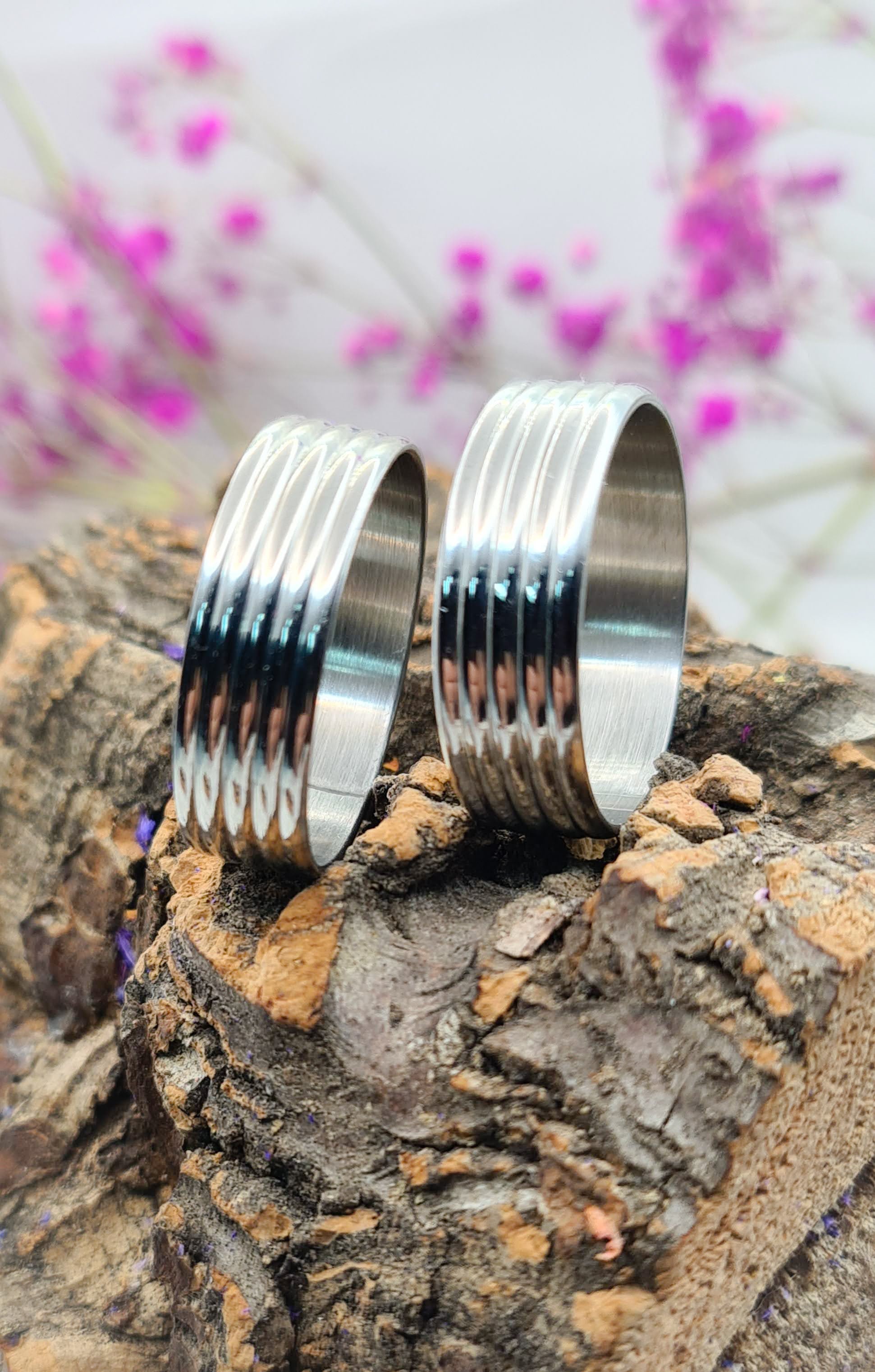 Dos Anillos tipo alianza de matrimonio o pareja en acero inoxidable bicolor y ancho de 6mm. Se incluye grabado de nombres y fecha importante gratis. Posan sobre tronco.